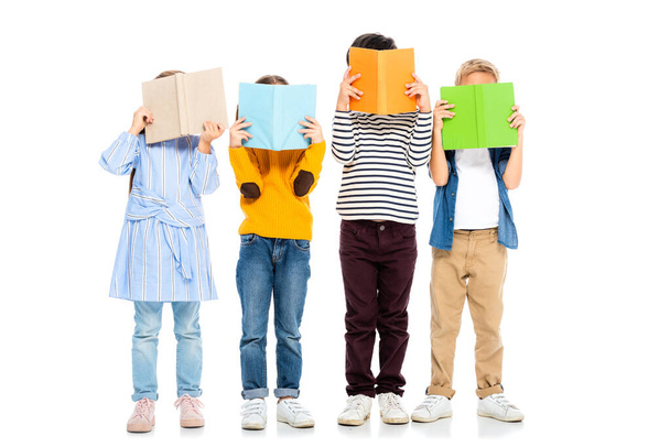Kinderen met kleurrijke boeken in de buurt van gezichten op witte achtergrond - Foto, afbeelding