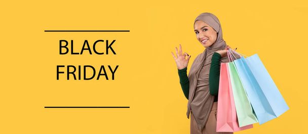 musulmana signora su shopping in posa con shopper borse, giallo sfondo - Foto, immagini