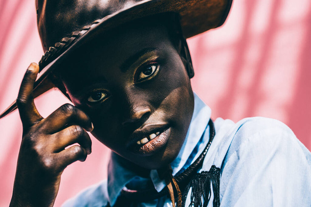 Afrikai lány nézi a lencsét. Törzsi divat hangulat. Kiváló minőségű fotó. Cowboy kalap. Szabadtéri - Fotó, kép