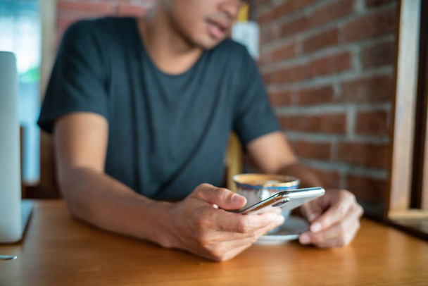Zakelijke mannen gebruiken smartphone zitten in coffeeshop hand close-up - Foto, afbeelding