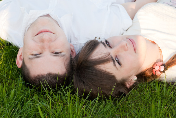 Homem e mulher jazem na grama
 - Foto, Imagem