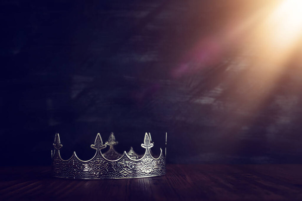 low key image of beautiful queen/king crown over wooden table. vintage filtered. fantasy medieval period - Fotó, kép