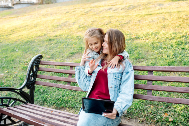 Una giovane madre e sua figlia di 7 anni scattano una foto congiunta al telefono - Foto, immagini