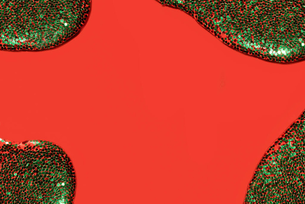 líquido transparente com glitter verde derramando sobre um fundo vermelho coral - Foto, Imagem