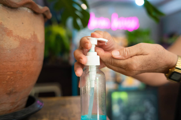 Las mujeres desinfectante de manos gel de alcohol manos limpias prevención de la higiene del brote de virus coronavirus antes de entrar en la tienda - Foto, Imagen