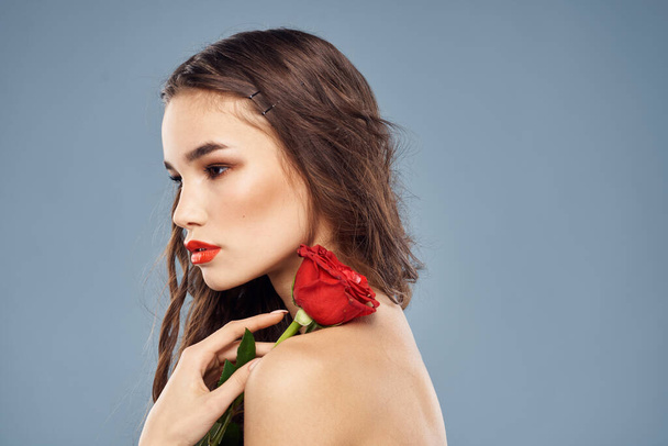 Frau mit einer Rose in den Händen nackte Schultern Abend Make-up rote Lippen - Foto, Bild