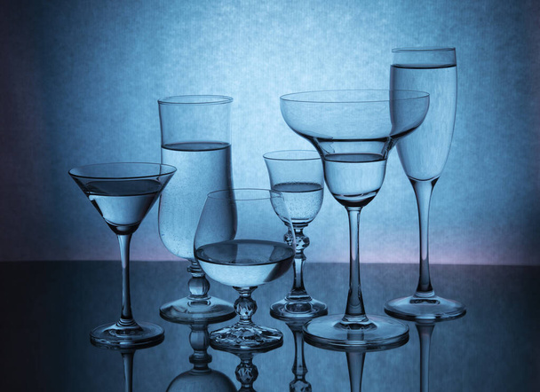 Seis copas de vidrio sobre un fondo degradado de color - Foto, Imagen