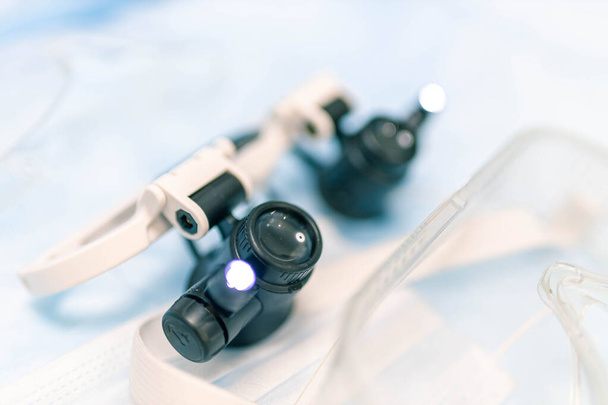Surgical glasses binoculars with object illumination lamps, medical equipment. - Fotoğraf, Görsel