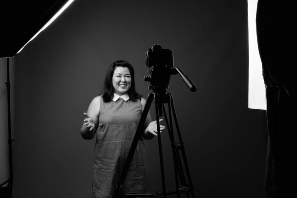 Beautiful overweight Asian woman against gray background - Fotografie, Obrázek