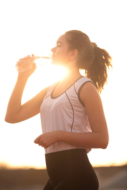 girl drinking water from the bottle At Outdoor Stadium - Φωτογραφία, εικόνα
