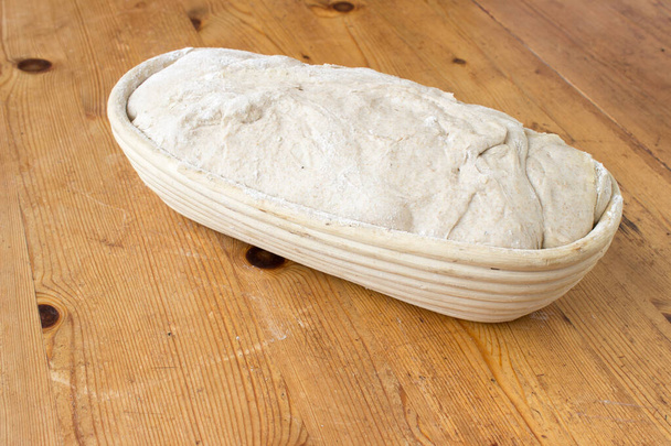 Primer plano sobre pan de masa fermentada en superficie de madera - Foto, imagen