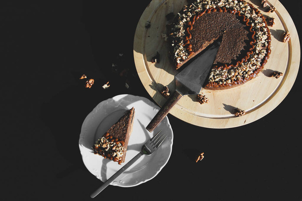Bolo de panqueca de chocolate com nozes. Um close-up de tarte. Bolo no fundo preto - Foto, Imagem