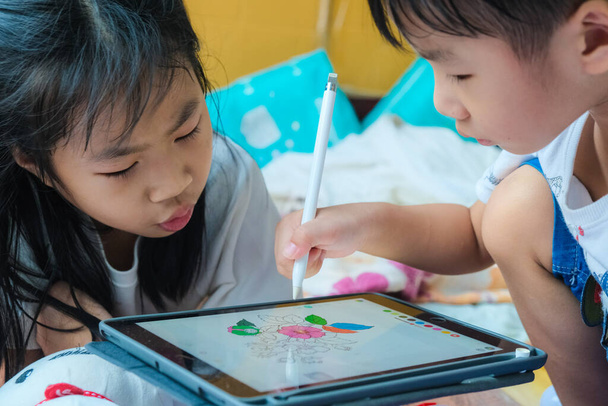 Kinderen tekenen beeld met tablet computer pen tijdens het spelen in huis kinderen leren kunst onderwijs - Foto, afbeelding