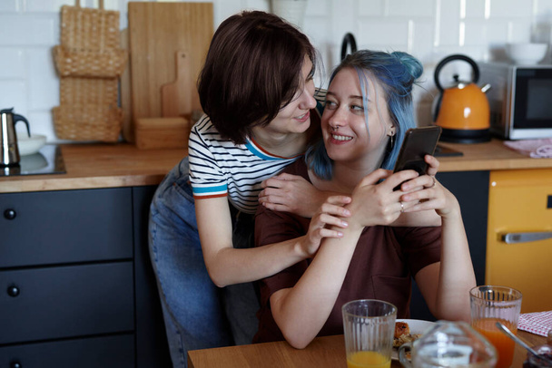 Happy lesbian couple hugging during breakfast                                - Photo, Image