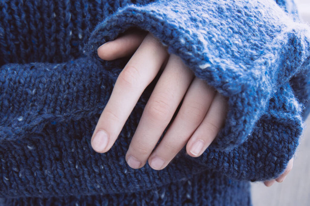 Femme en doux pull tricoté bleu foncé chaud plié ses mains. Automne bientôt - Photo, image