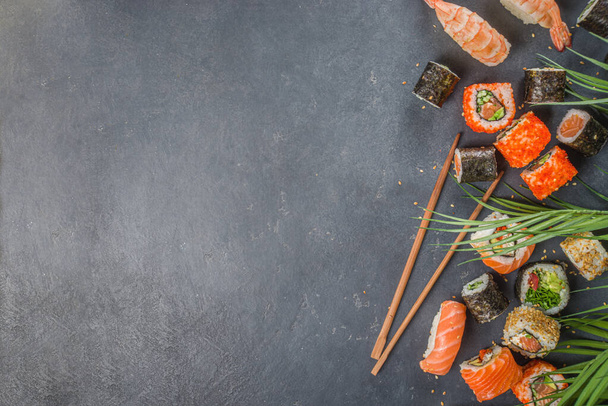 Set de sushi con palillos. Varios sushi japonés delicioso, rollo de piezas y nigiri sobre fondo azul claro - Foto, Imagen