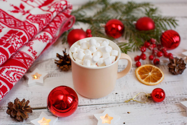 Vánoční pozadí, hrnek na kávu a marshmallows, červené vánoční hračky, zářící světla. Veselé vánoční přáníčko - Fotografie, Obrázek