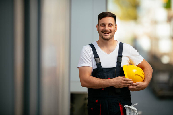 usmívající se muž stavitel se žlutou přilbou  - Fotografie, Obrázek