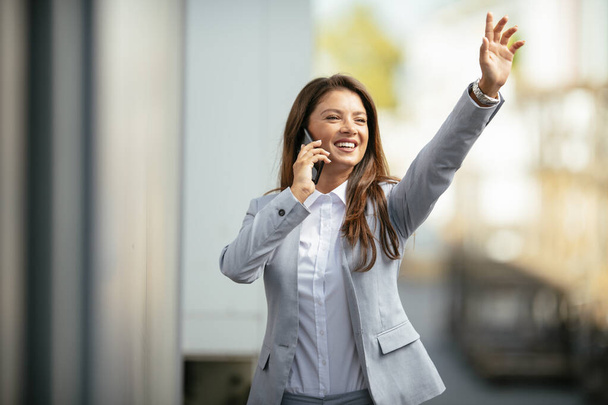 mosolygós nő beszél telefonon és integetett kézzel - Fotó, kép