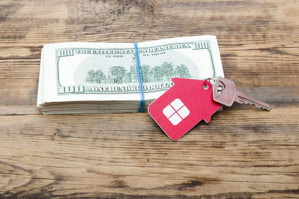 Ключи от дома на сто долларов против деревянной спины
 - Фото, изображение
