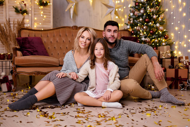 Conceito de Natal, família e amor - bela família na sala de estar decorada com árvore de Natal, presentes e luzes - Foto, Imagem