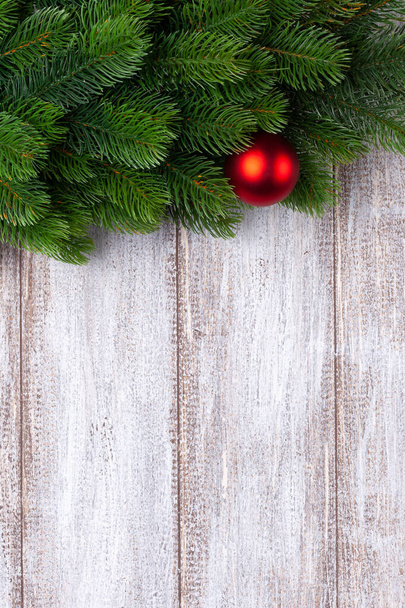 red ball on the branches of a Christmas tree on a wooden background, mock up - Fotoğraf, Görsel