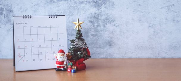 Calendario de diciembre y decoración de Navidad - Santa Claus, árbol y regalo en mesa de madera. Navidad y feliz año nuevo concepto - Foto, Imagen