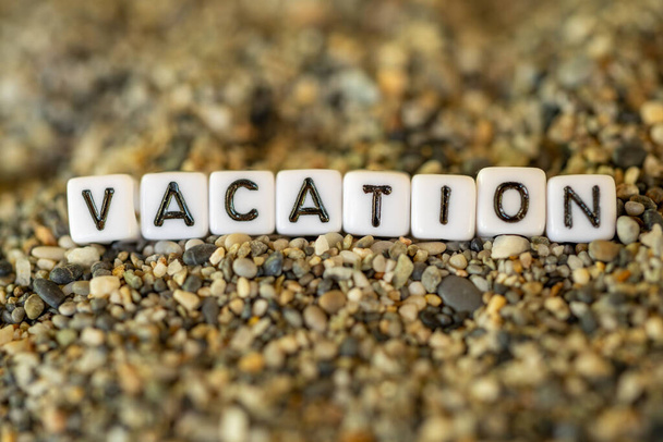 Текст відпустки з назвою міста призначення відпустки в натюрморті листів, викладених на берегових піщаних каменях
 - Фото, зображення