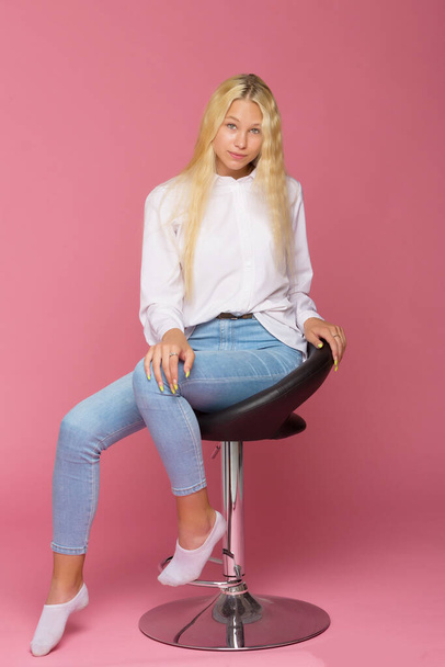 Cute Smiling Blonde Girl Sitting on High Chair in Studio - Fotó, kép