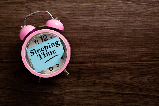 Sveglia con la parola Sleeping Time sulla nota appiccicosa. Concetto sano - Foto, immagini