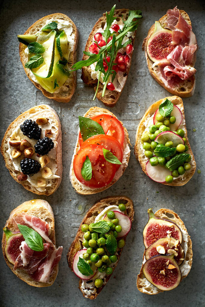 set of tasty bruschettas with toppings on metallic tray. Snack finger food meal for wine. Top view  - Foto, Imagen