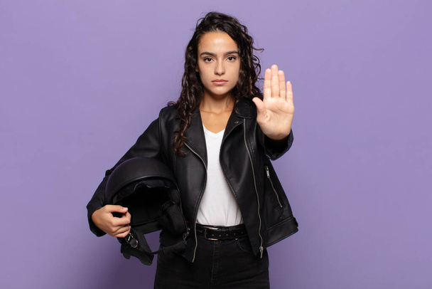 young hispanic woman looking serious, stern, displeased and angry showing open palm making stop gesture - Foto, immagini