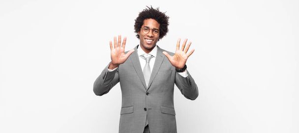 negro afro hombre de negocios sonriendo y buscando amigable, mostrando el número diez o décimo con la mano hacia adelante, cuenta atrás - Foto, Imagen