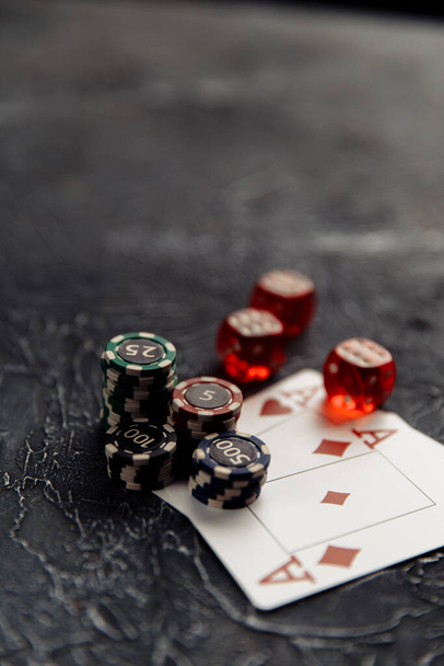 Μάρκες, τρεις κόκκινες ζάρια και τραπουλόχαρτα με άσους για online πόκερ ή τυχερά παιχνίδια καζίνο στο τραπέζι close-up. Online καζίνο έννοια - Φωτογραφία, εικόνα