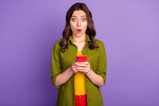 Portrait of astonished girl use cellphone impressed social media information stare stupor wear good look clothes isolated over purple color background - Foto, Bild