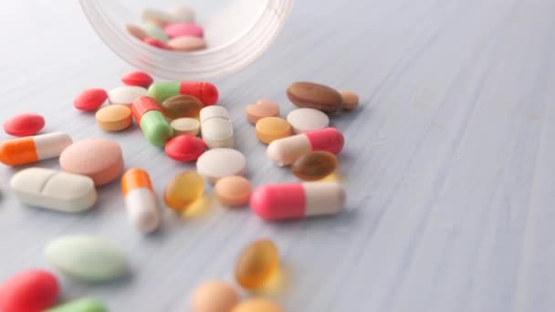 közeli-ból színes tabletták ömlött fehér háttér  - Felvétel, videó