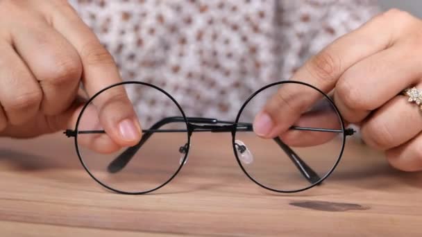Primer plano de la mano de las mujeres sosteniendo gafas clásicas - Imágenes, Vídeo
