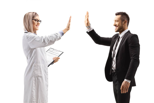 Female doctor making high-five gesture with a businessman isolated on white background - Foto, imagen