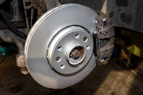 New brake disc with an anti-corrosion layer, mounted on the front hub. - Photo, Image