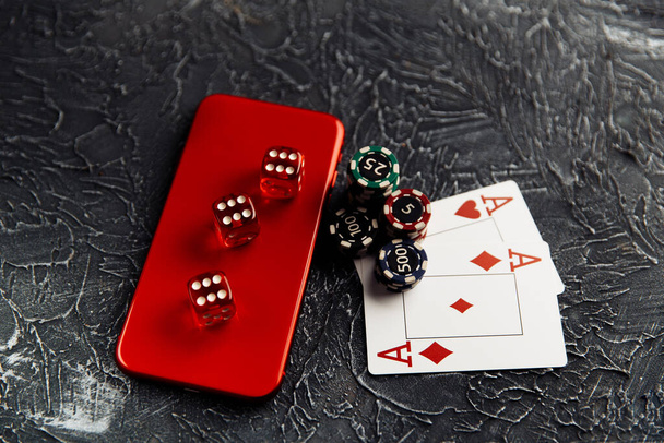 カジノはオンラインでプレイ。チップ、カード、赤いダイス、スマートフォンを再生する - 写真・画像