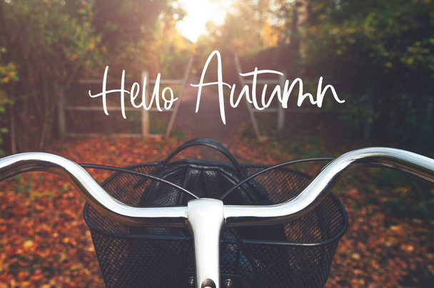 Hallo Herbst Text, Postkartenkonzept. Vintage gerahmtes Fahrrad mit Korbständer in herbstlicher Umgebung, Radfahren auf dem Land und das Leben genießen - Foto, Bild