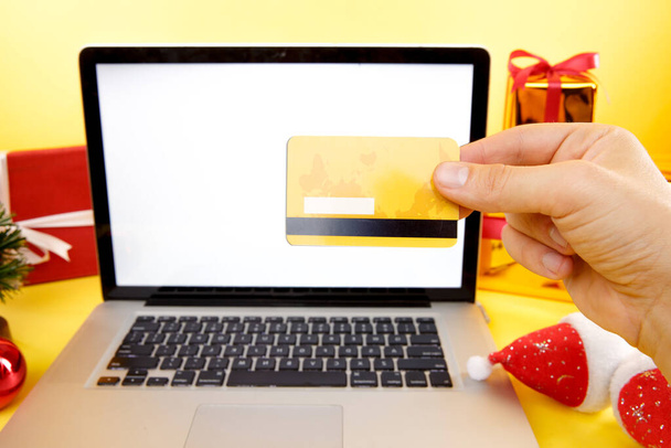 Tula, 28 09 19: shopping online concept. Credit card and laptop with christmas gifts and boxes. - Fotó, kép