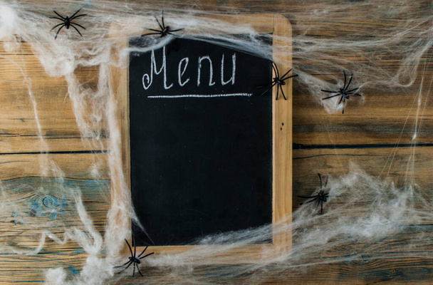 Halloween menu napsané na tabuli nad starým venkovským dřevěným stolem. šablona prázdninového menu s místem pro kopírování. Kopírovat místo pro text.  - Fotografie, Obrázek