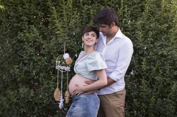 Junges Paar schwangere Frau und Mann auf grünem Hintergrund. - Foto, Bild