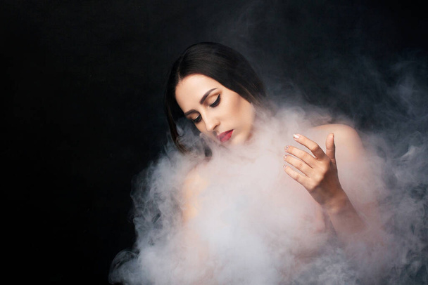 Attractive young girl and white smoke. - Foto, afbeelding