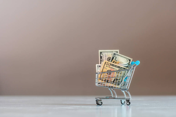 shopping cart full of dollar bills , business, finance, economy concept - Foto, Imagem