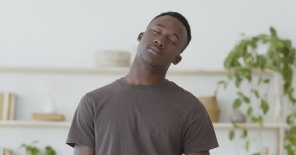 Aamutreenit. Nuori musta mies lämmittää kaulaansa kotona - Materiaali, video