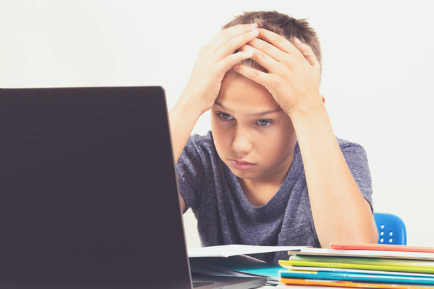 Дитина з портативним комп'ютером робить домашнє завдання вдома. Технології, онлайн навчання, дистанційна освіта
 - Фото, зображення