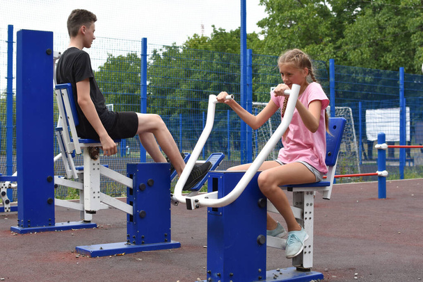 children on sports outdoor sports simulators. healthy teenagers do sports exercises - Foto, Imagen