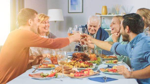 Big Family and Friends Celebration at Home, Diverse Group of Children, Young Adults and Old People Gathered at the Table have Fun Conversation. Clinking Glasses and Making Toast. - 写真・画像